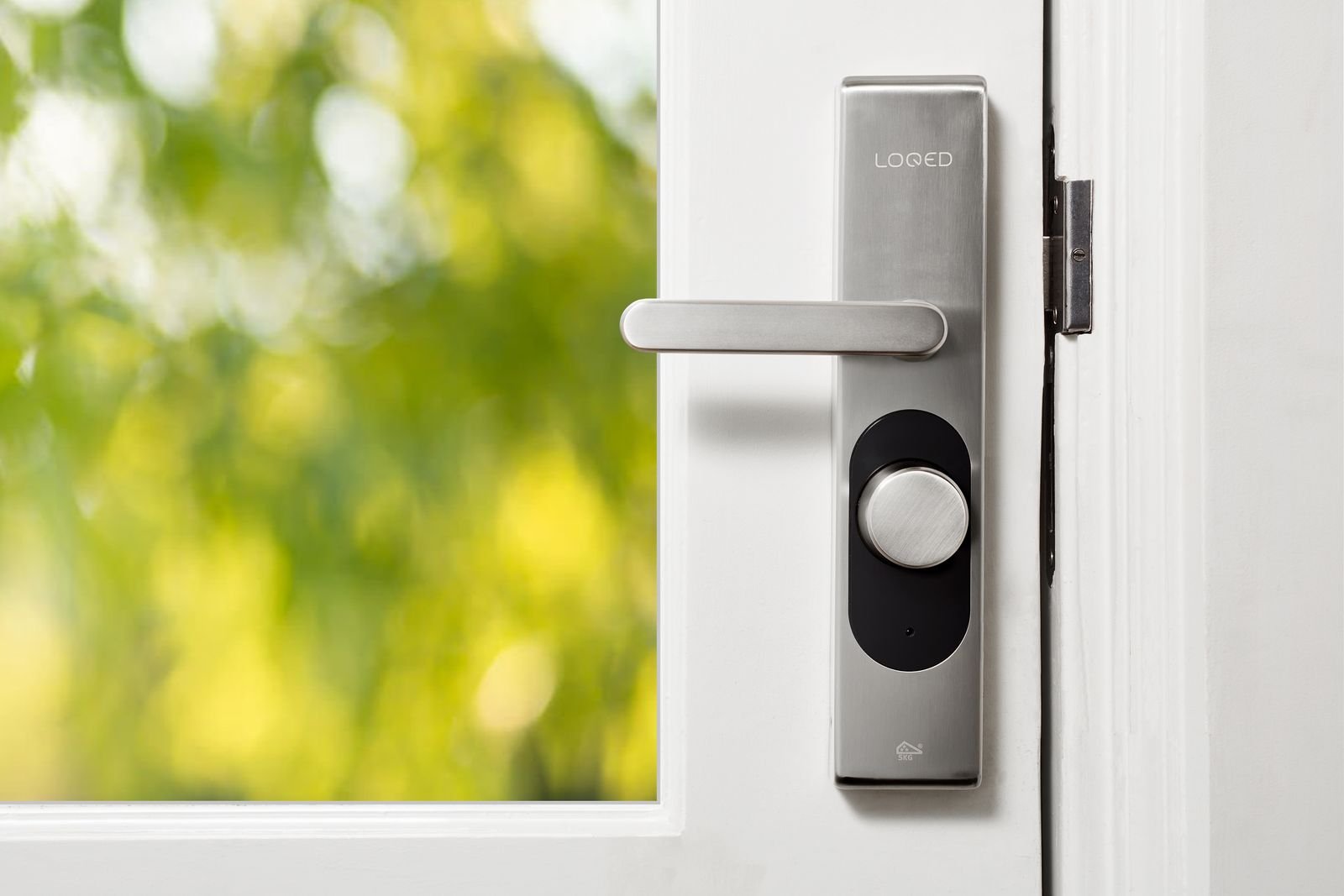 LOQED smart lock installed on a white front door